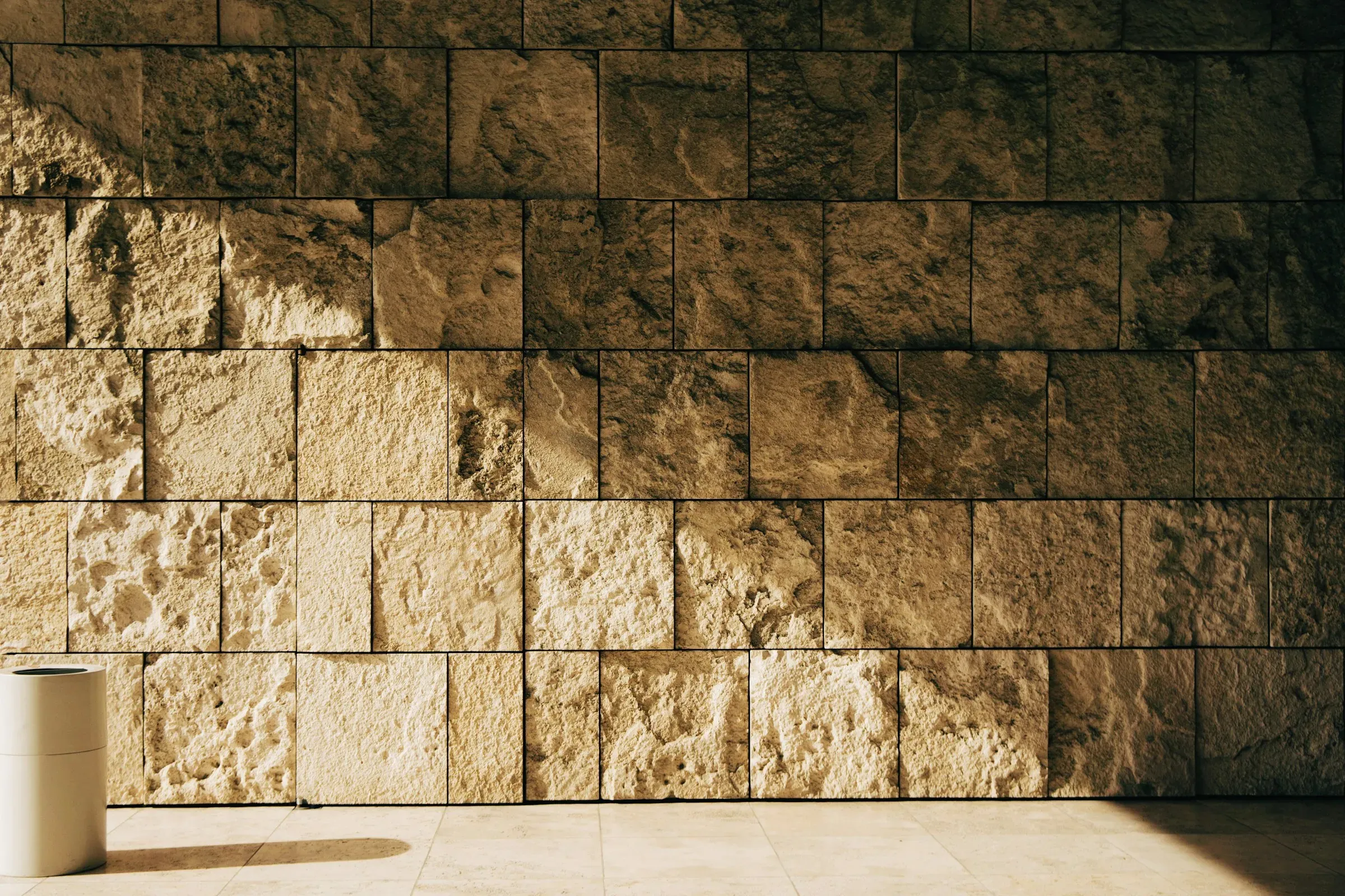 Mur de blocs daurats amb llum rasant