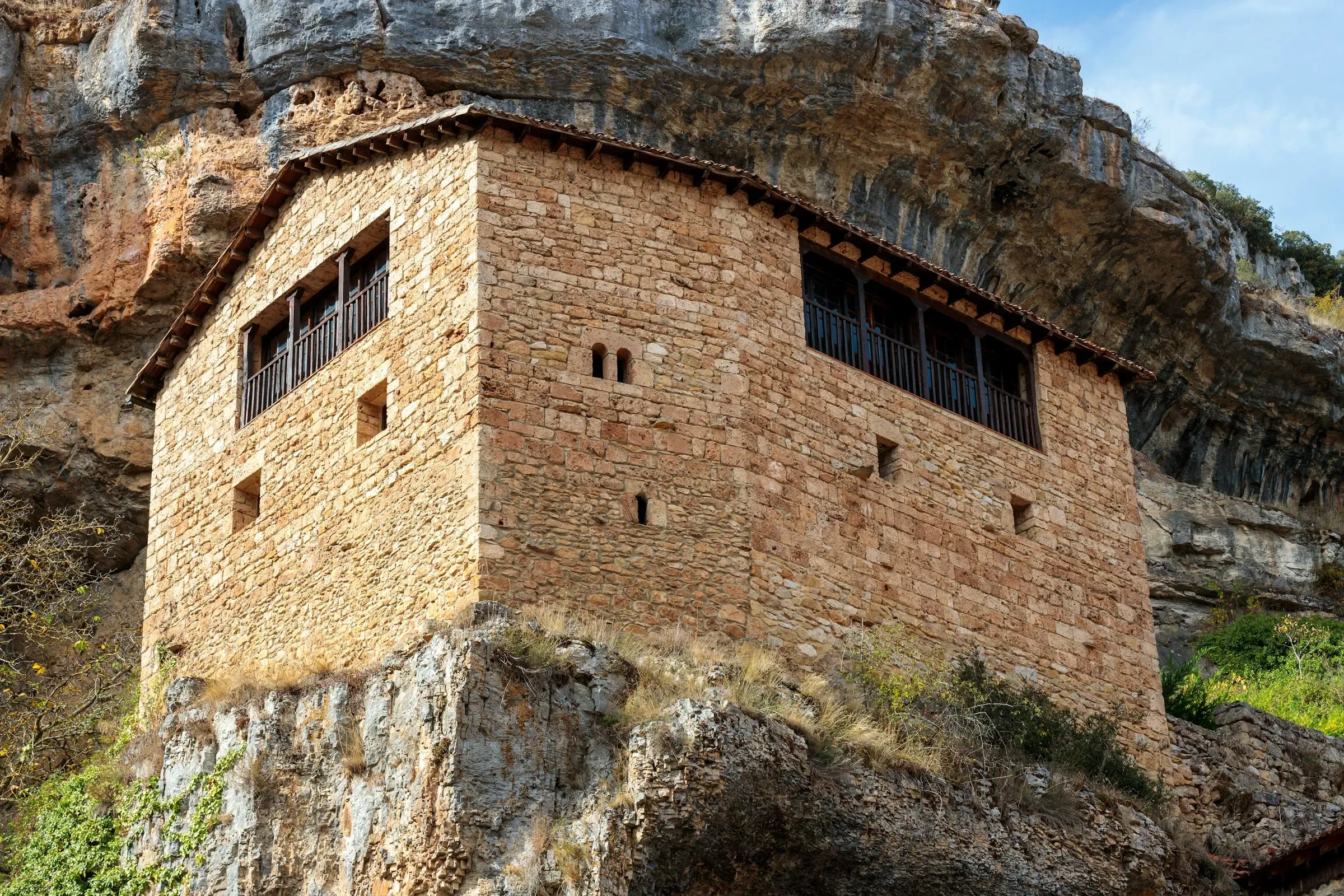 Casa antiga de pedra adossada a una cinglera